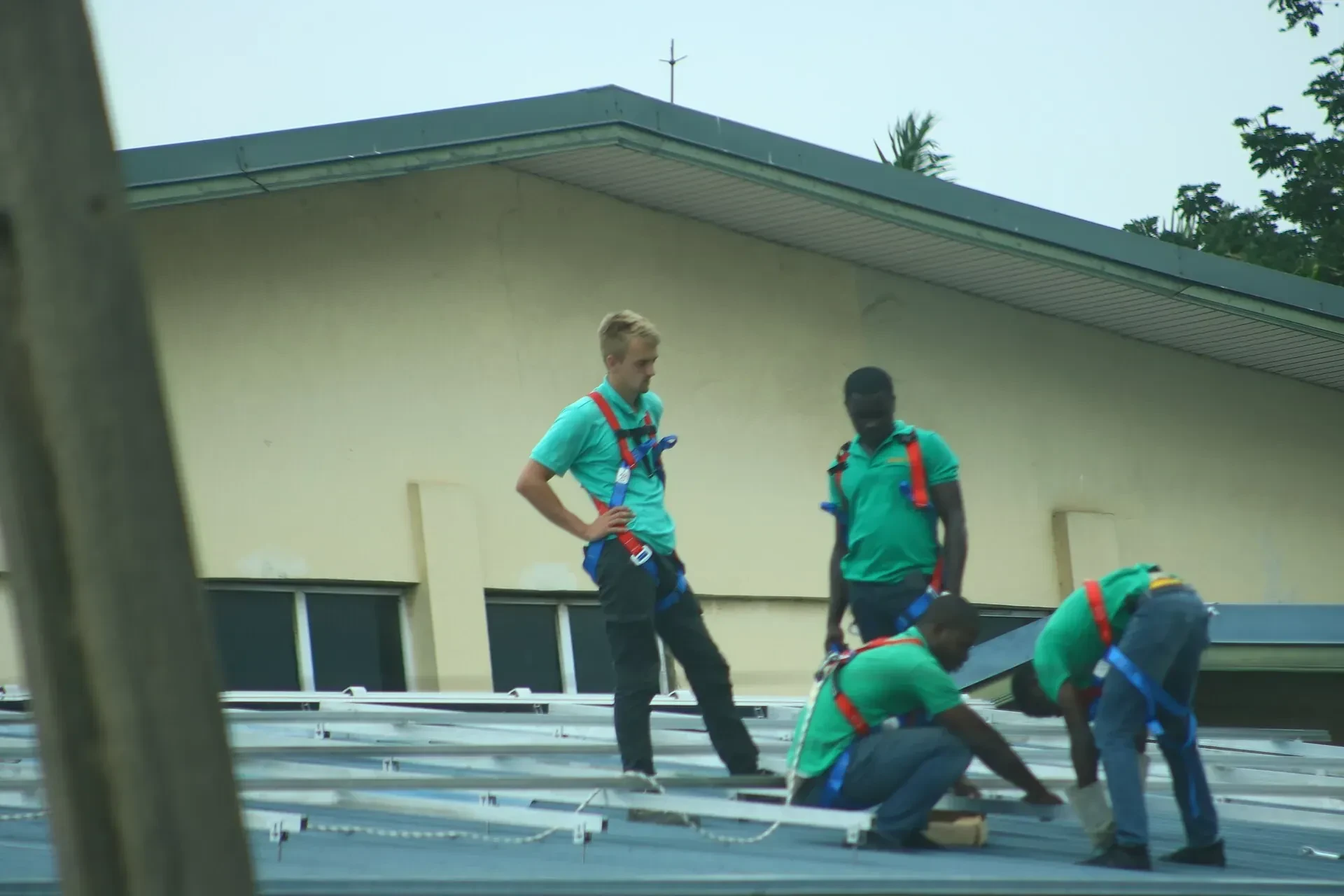 Technicians installing solar panels on a roof in Ghana